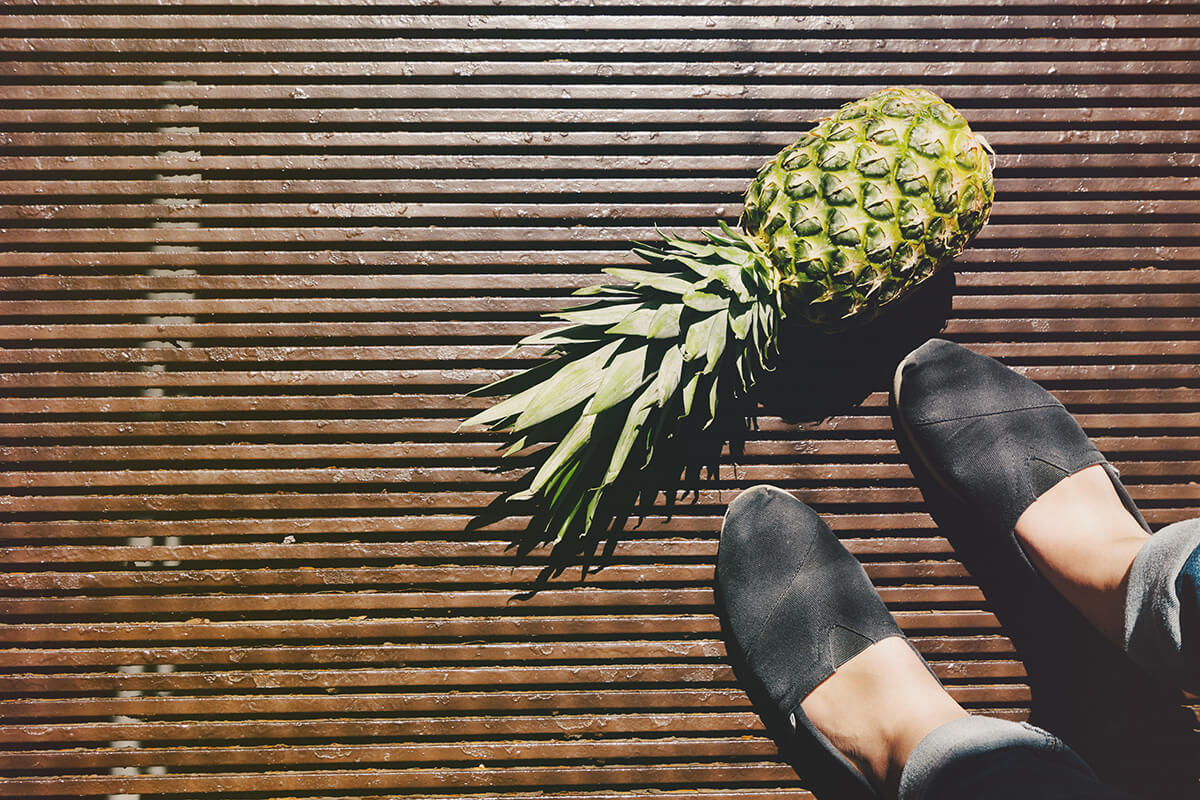 voeten van een vrouw met ananas op de grond